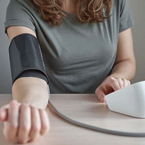 Woman taking home blood pressure test